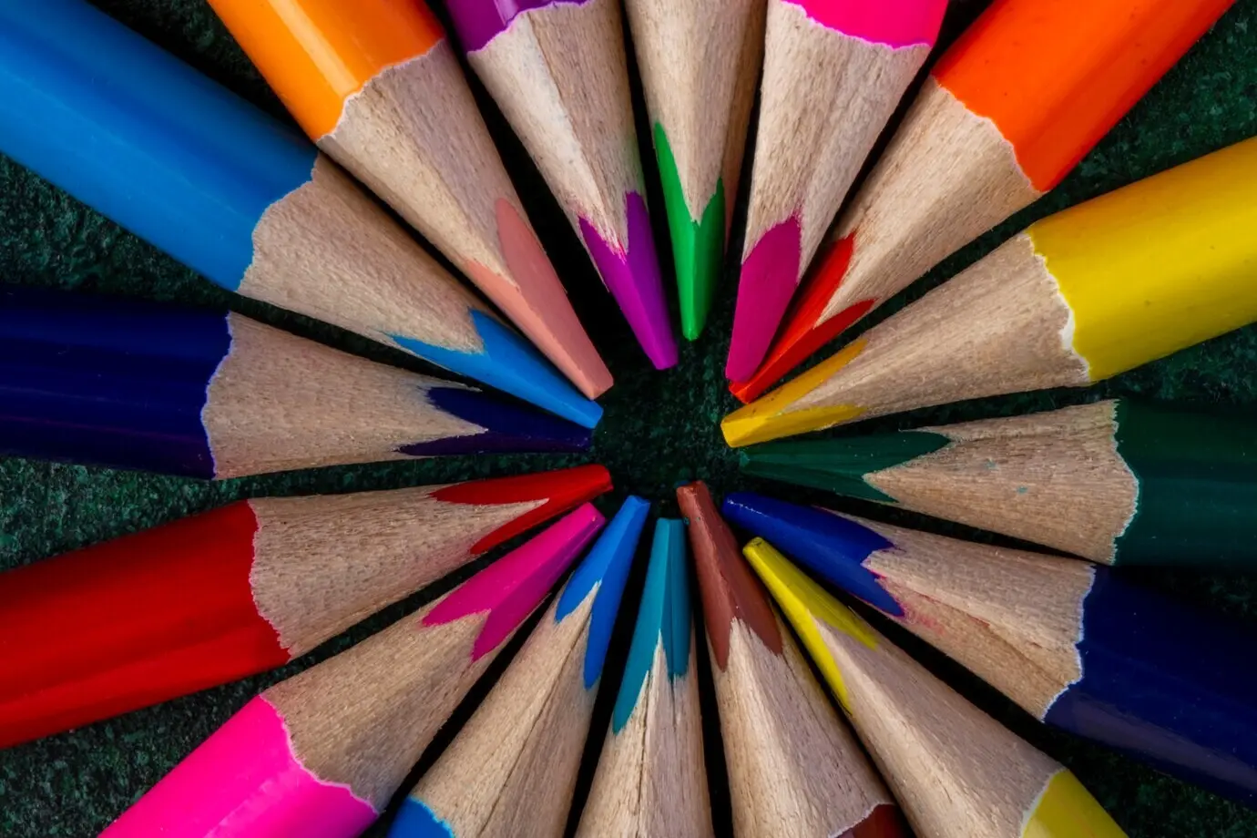 Draufsicht auf Buntstifte auf dunklem Untergrund.